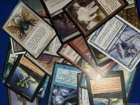 Loose Magic: The Gathering cards piled showing various creatures and card texts