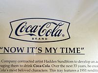 Close-up photo of Coca-Cola branding and historical information on the artist Hadden Sundblom who created the Santa image.