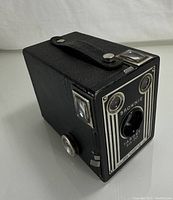 Side angled view of the Kodak Brownie Target Six-20 box camera showing leatherette body, winding knob, and top strap