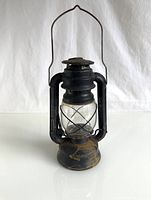 Front view of the black metal lantern standing upright with visible glass globe and metal handle.