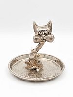 Front view showing the seated cat figure and floral engraved tray with beaded edge.