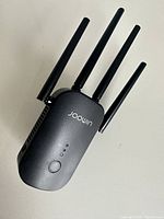 Front view of Joowin WiFi extender device with four external antennas and brand name visible.