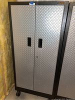 Front view of closed cabinet showing diamond plate doors and black frame