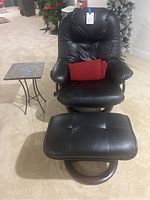 Overall view showing armchair, ottoman, side table and red blanket