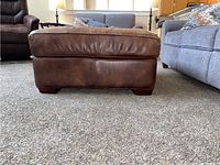 Front view showing brown leather upholstery and base