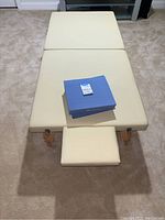 Top view of cream-colored Saloniture stretching table with two blue Strongtek wedges placed on top.