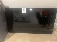 Front view of Samsung 43-inch LED TV with blank screen, sealed price tag attached.