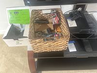Photo shows Destek V5 Virtual Reality headset with quick start guide, a woven basket containing multiple AA batteries, and Sony PlayStation 3 console with a single controller resting on top.