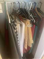 Closet section showing assorted folded and hanging tablecloths in various colors and patterns