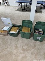 Four plastic tubs on basement floor containing stamp albums and envelopes