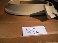 Photo showing coiled flexible resin trim molding on cardboard surface with section detail visible.