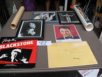 View of lot content showing two Blackstone albums, three framed magician photos, rolled magician posters, and a yellow envelope