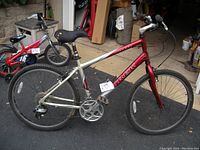 Full side view of Trek Navigator 100 mountain bike showing red and silver frame, 26-inch wheels, and saddle.