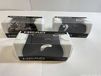 Three boxed pairs of Head Impulse goggles with clear lenses and black straps in plastic display cases.