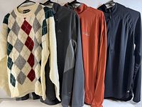 Front view of all four men's large clothing items on hangers including Shetland wool sweater and three jackets