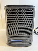 Front view of Ecoquest Freshair air purifier showing metal mesh grille and digital display panel with control buttons.