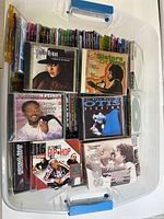 Top view of plastic bin with CDs showing various album covers featuring soul, hip hop, and blues artists