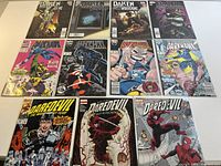 Top-down view of all 11 comic books arranged in three rows, showing front cover art for Daredevil (3), Darkhawk (4), and Daken Dark Wolverine (4) comics.