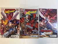Three Marvel comic books titled Deadpool vs X-Force, individually sleeved and laid side by side.