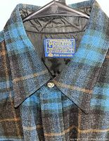 Close-up photo of the Pendleton label inside the collar showing 100% pure virgin wool and size 16.