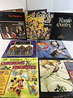 Seven vintage vinyl LP records covering comedy, country, soul, and children's genres, showing front covers and arranged in two rows.