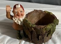 Photo showing a gnome ceramic planter with rustic tree bark style pot with green moss accents