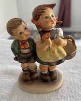 Front view of the Goebel Hummel figurine showing two children standing on an oval base.