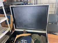 Open blue metal forge anvil trunk showing contents: hats, belts, and canteen.