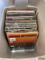 Container filled with over 70 old vinyl records showing album cover of Tower of Power at front
