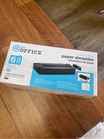 Photo of product box showing brand, model, and paper shredder specifications such as 6 sheets capacity, strip-cut type, and warranty.