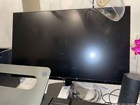 Front view of Dell 27 inch monitor with cables on desk and base stand
