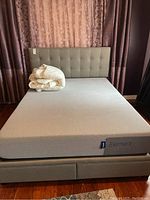 Full view of bed frame with Casper Element mattress and folded white bedding on top