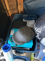 Overhead view of plastic tub showing X5 Hair Laser box, black case, turquoise box and manuals