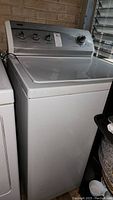 Front and top view of white Kenmore 600 washing machine showing control panel with dials and overall condition.