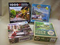 Four 1000-piece puzzle boxes stacked and arranged showing cover artwork and branding.