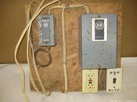 Full setup of Allen Bradley temperature control unit mounted on a wooden board showing power outlet, metal enclosures, wiring, and manual/auto switch.