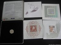 Full view of contents inside the metal collector's tin including stamps, booklet, and coin