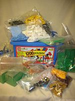 A photo showing several bags of LEGO bricks sorted by color including yellow, white, light blue, green, and black with a LEGO 1200 piece box visible.