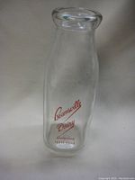 Front view of vintage Beamsville Dairy milk bottle showing red logo and clear glass.