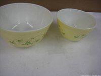 Two yellow vintage Pyrex nesting bowls side by side.
