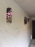 Three carved wooden African masks mounted on a wall, showing size and placement