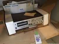 Akai 6-track stereo cassette deck in original box with foam inserts and documents.