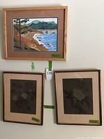 Overall view of all three framed art pieces on wall including labels with dimensions