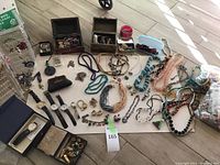 Overview of entire assortment of jewelry pieces laid out on floor