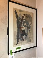 Image of the framed abstract art print hanging on wall with a measuring tape showing 26x21 inches.