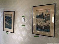 Photo showing two of the framed Japanese art prints displayed on a wall, framed in black with beige matting.