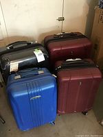 Four luggage suitcases grouped together showing colors and sizes