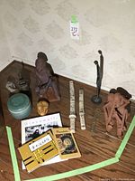 Overall assortment of sculptures, decorative objects and books arranged on floor