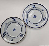 Top view of two vintage Tiffany & Co soup bowls showing blue floral pattern and gold rim on white ceramic with scalloped edges.