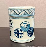 Front and side view of antique blue and white ceramic ball flower jar showing hand-painted circular blue patterns and lid with diagonal hatch design.